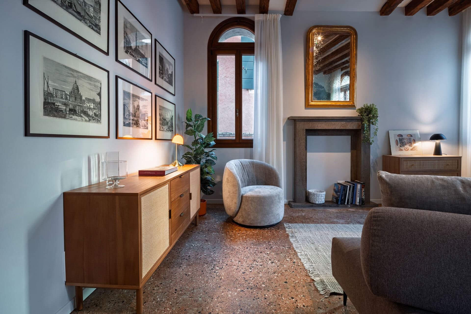 The Red House Company - A refined and welcoming space where modern design meets Venetian charm. The living room features elegant furnishings, soft lighting, and a cozy ambiance, perfect for relaxing after a day exploring the city.