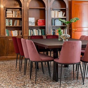 Elegant dining room with a dark wood table and pink velvet chairs.